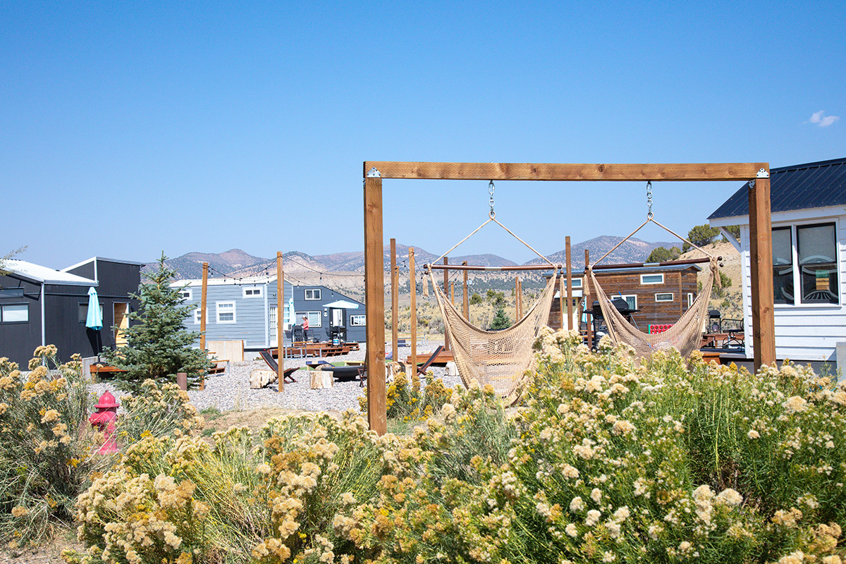 Lush, blooming foliage surrounds the ring of tiny homes and communal space at Meeker's Trail and Hitch in Colorado.