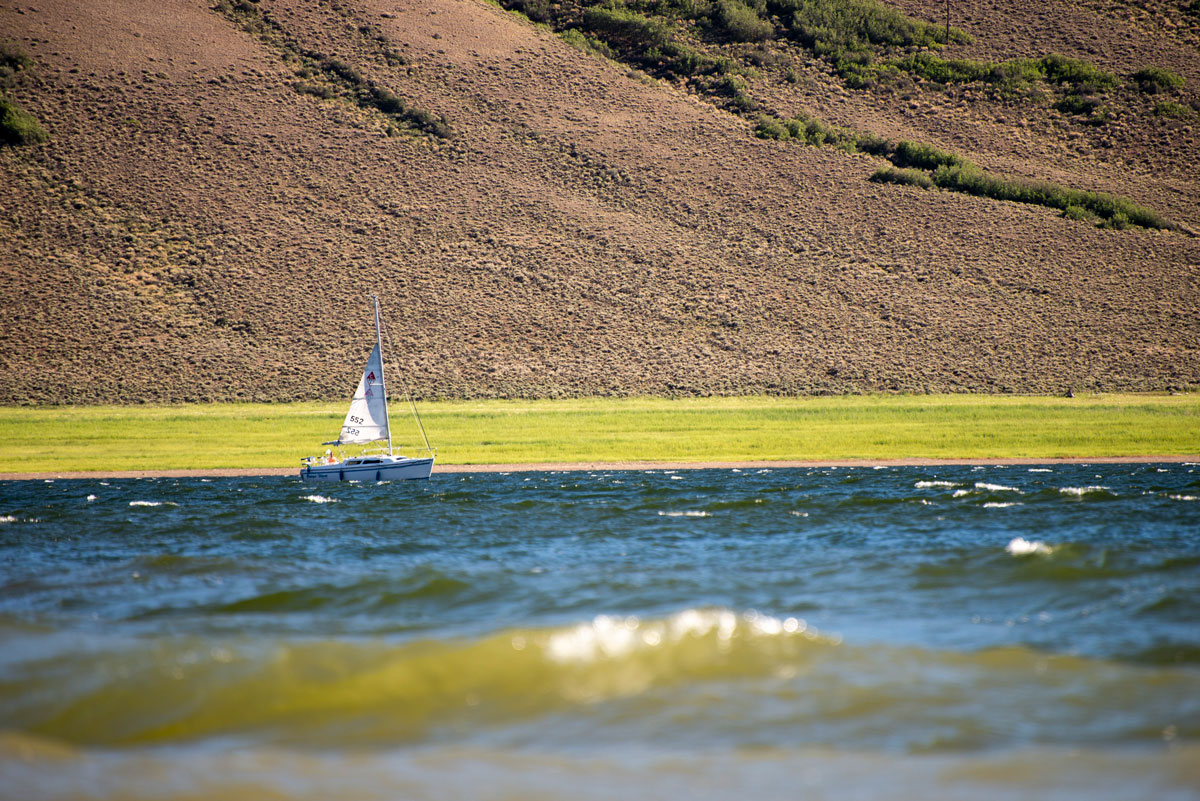 People sailboating on Blue Mesa Reservoir under sunny skies in Gunnison.