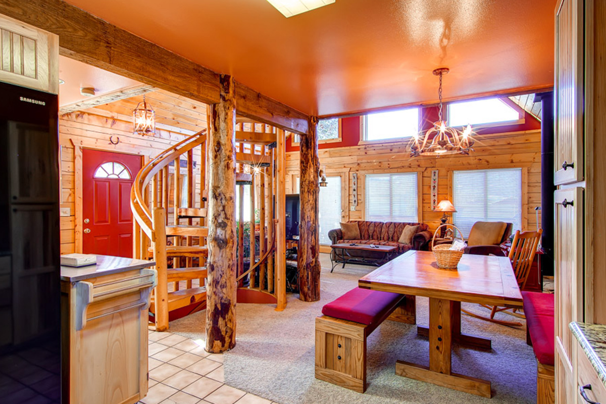 Inside 597 Deerpath, you can see a large dining room table, an open living room and a handcrafted, wooden spiral staircase.