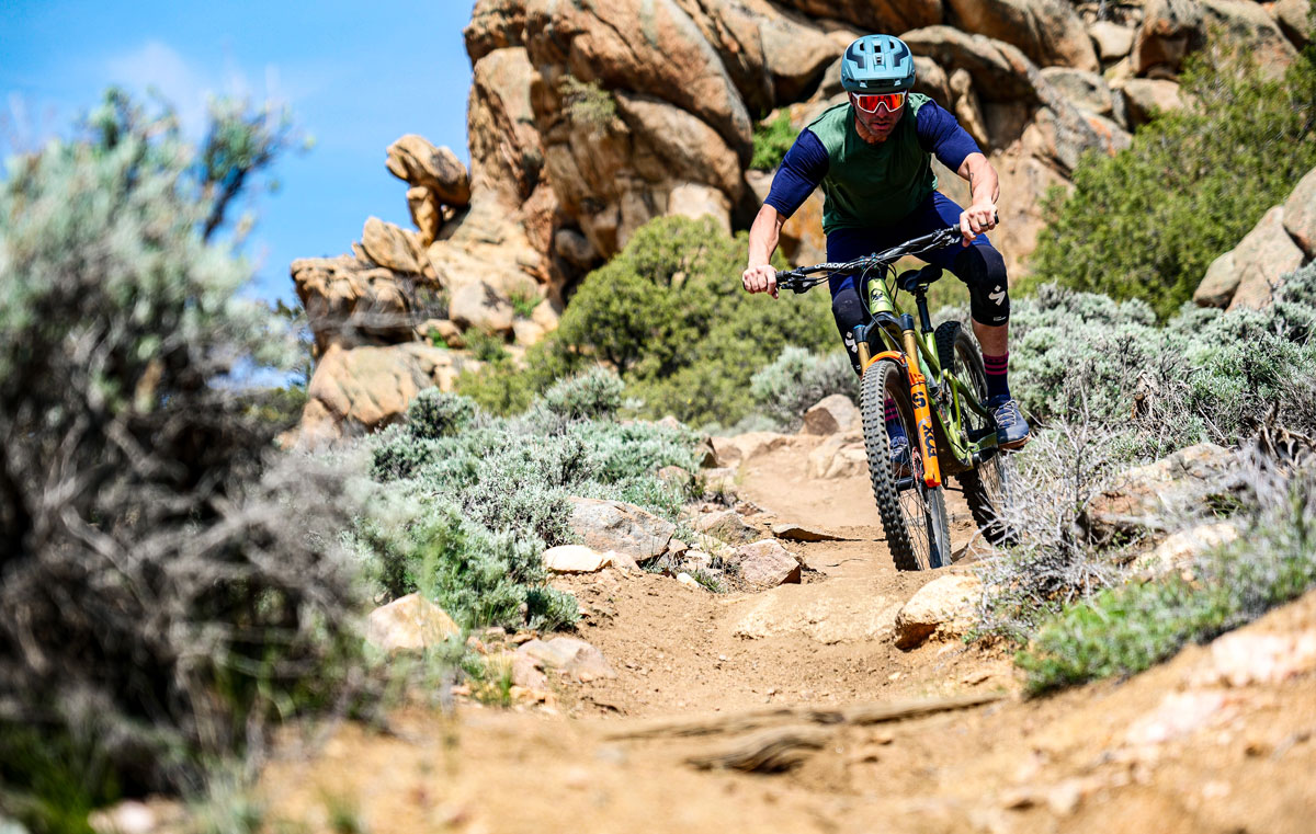 Man mountain biking downhill at Hartman Rocks on rocky terrain.