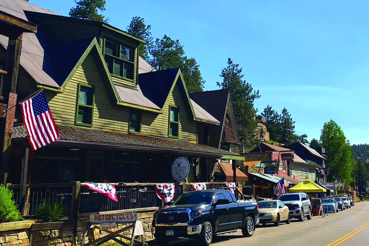 Downtown Evergreen street lined with stores and shops with flags hanging outside.