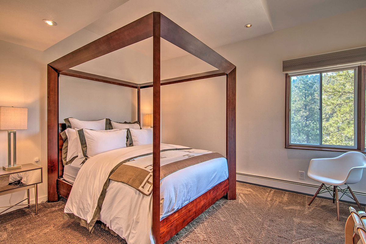 A bedroom at Barret House, near Boulder, Colorado, features a four-poster bed with geometric style.