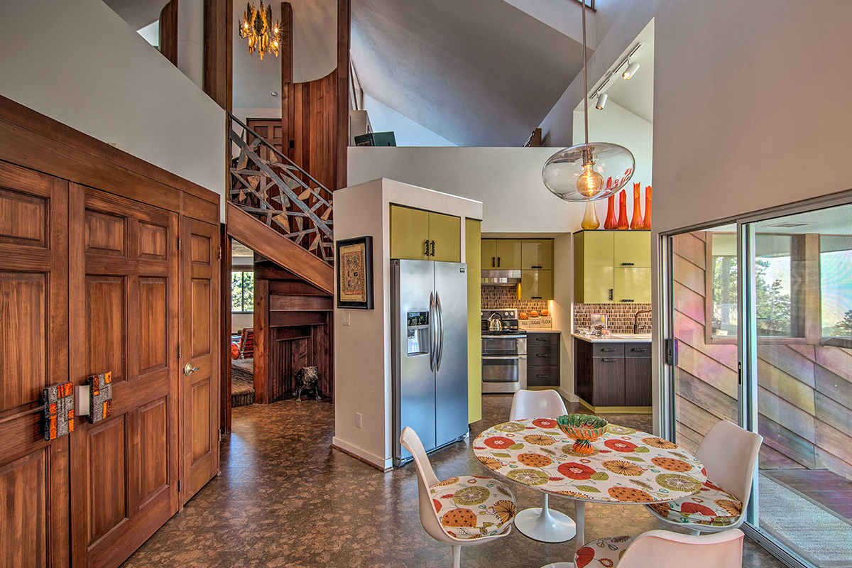 The kitchen and dining area feature organic elements, like wood, and a retro design to create Barret House's mid-century modern-style.