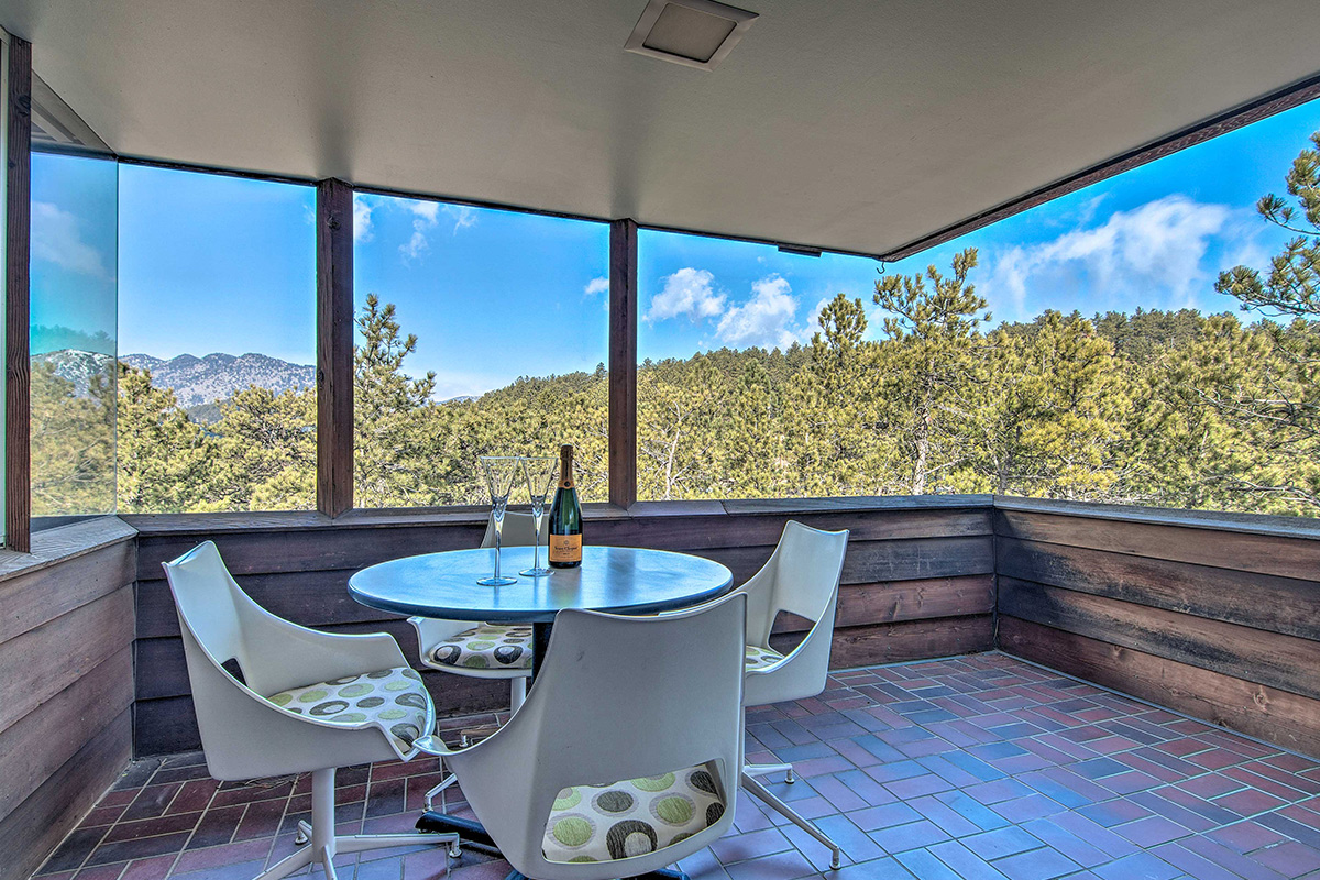 A shaded patio at Barret House offers a place to relax and take in forest and mountain views near Boulder, Colorado.