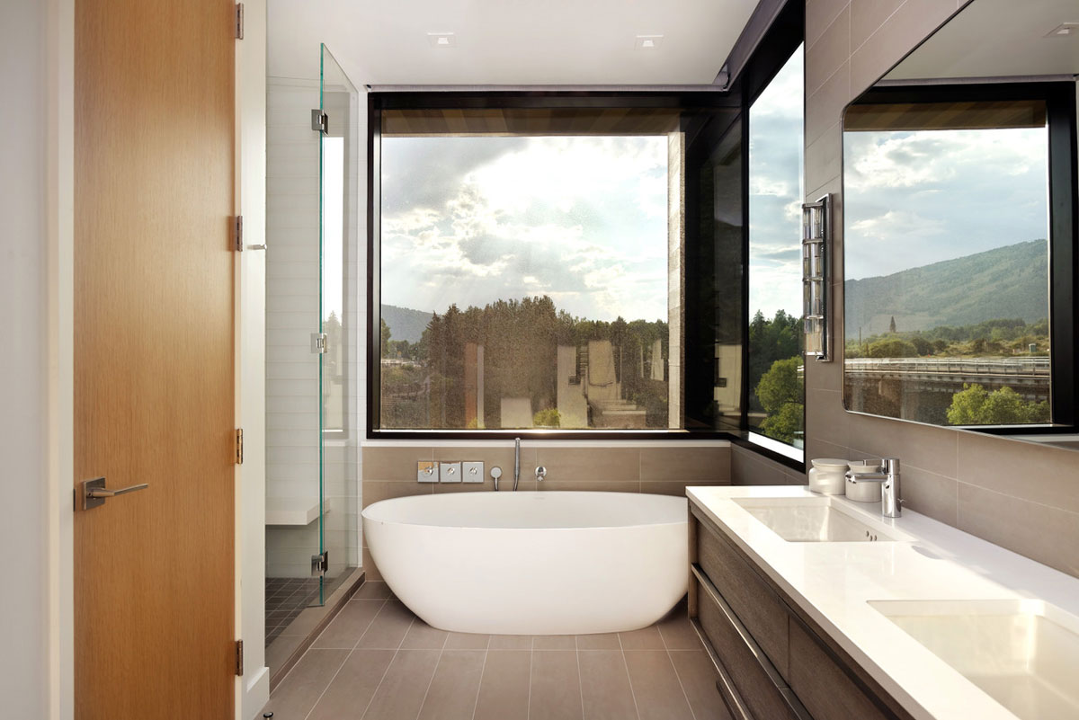 Well-lit bathroom filled with natural light and a bathtub centered in a bathroom in Aspen, Colorado.