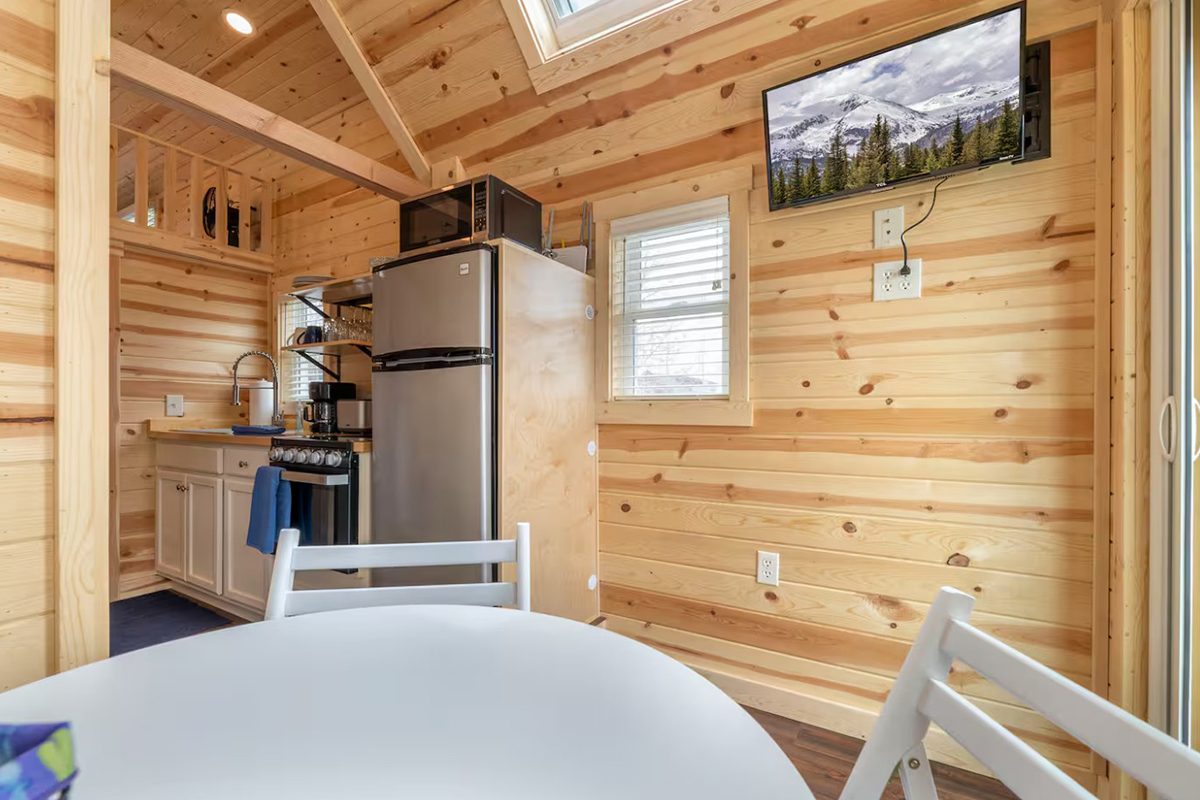 From the Tumbleweed's dining nook, you can see a TV, a skylight and a well-equipped kitchen.