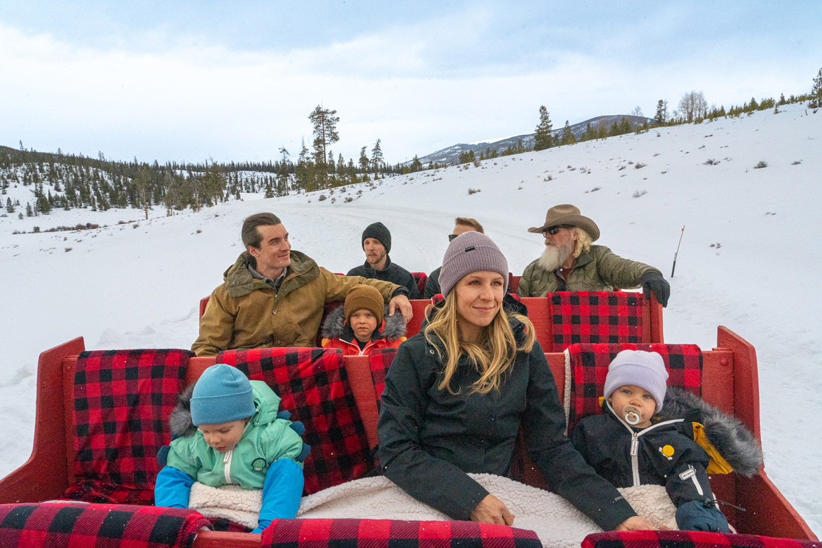 A family rides in a horse-drawn sleigh