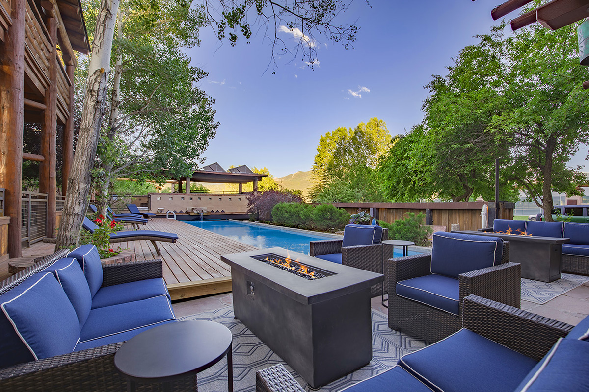 Cushy, blue patio furniture sits around firepits and a refreshing pool at the Chipeta Lodge Resort + Spa in Ridgway, Colorado.