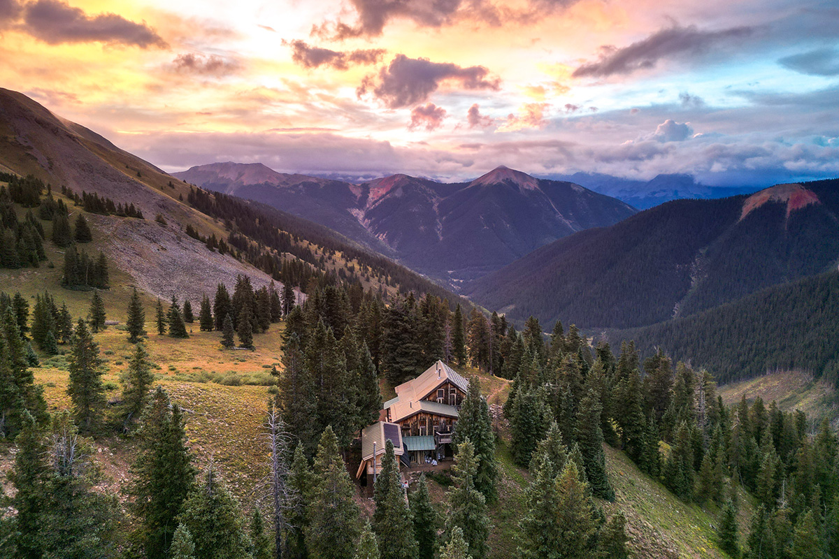The OPUS Hut sits high up on the edge of a valley in the San Juan Mountains surrounded by stands of pine near Telluride and Silverton, CO.