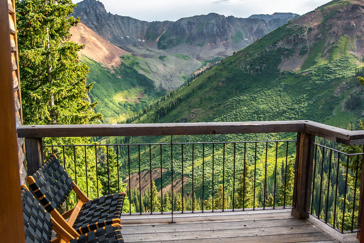 Get cozy on the wooden deck at OPUS Hut near Telluride, Colorado, and take verdant, jaw-dropping views of the valley.