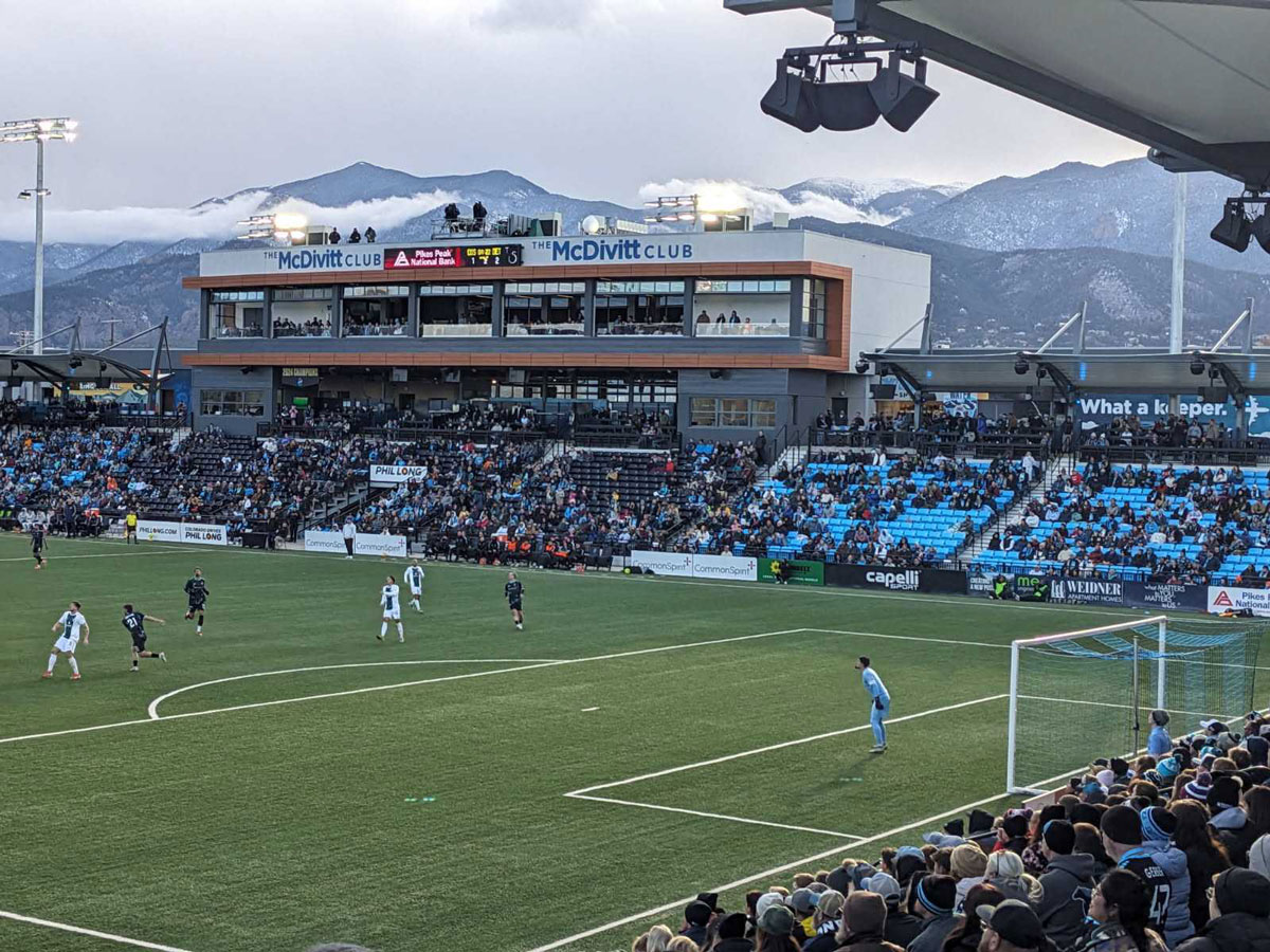 The Colorado Springs Switchbacks FC play at Colorado Springs Switchbacks at Weidner Field, framed by snow-capped mountains.