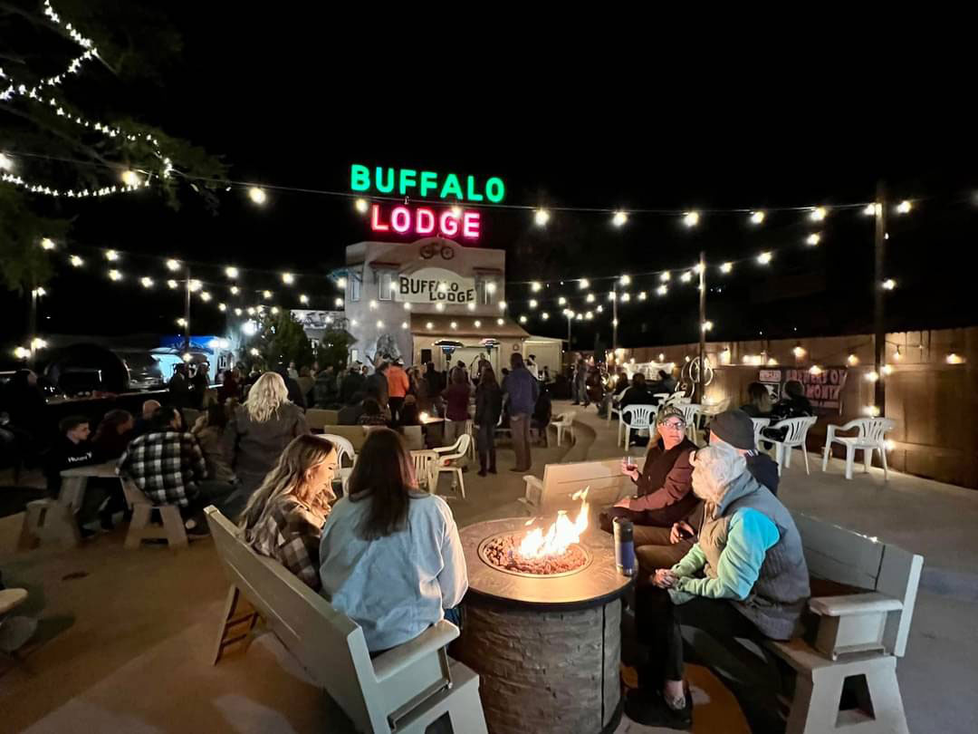 Patrons gather around a campfire on the patio of the Buffalo Lodge Bicycle Resort in Colorado Springs. 