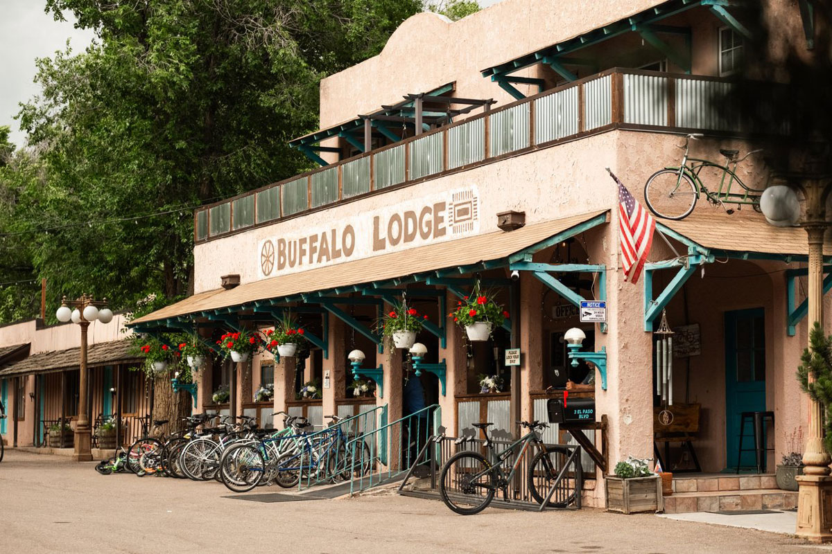 Rows of bicycles parked outside the stucco Buffalo Lodge Bicycle Resort in Colorado Springs.