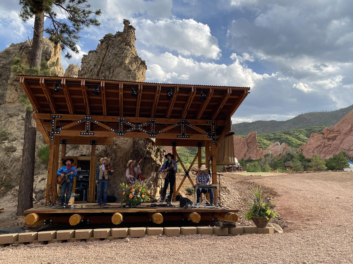 Musicians perform with string instruments and cowboy hats at Flying W Ranch in Colorado Springs, Colorado. 