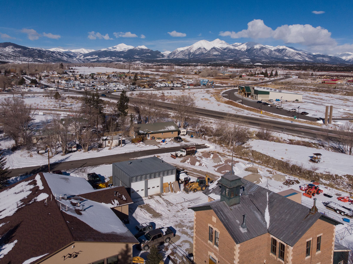 An aerial view of Poncha Springs, Colorado blanketed in snow except for plowed roads