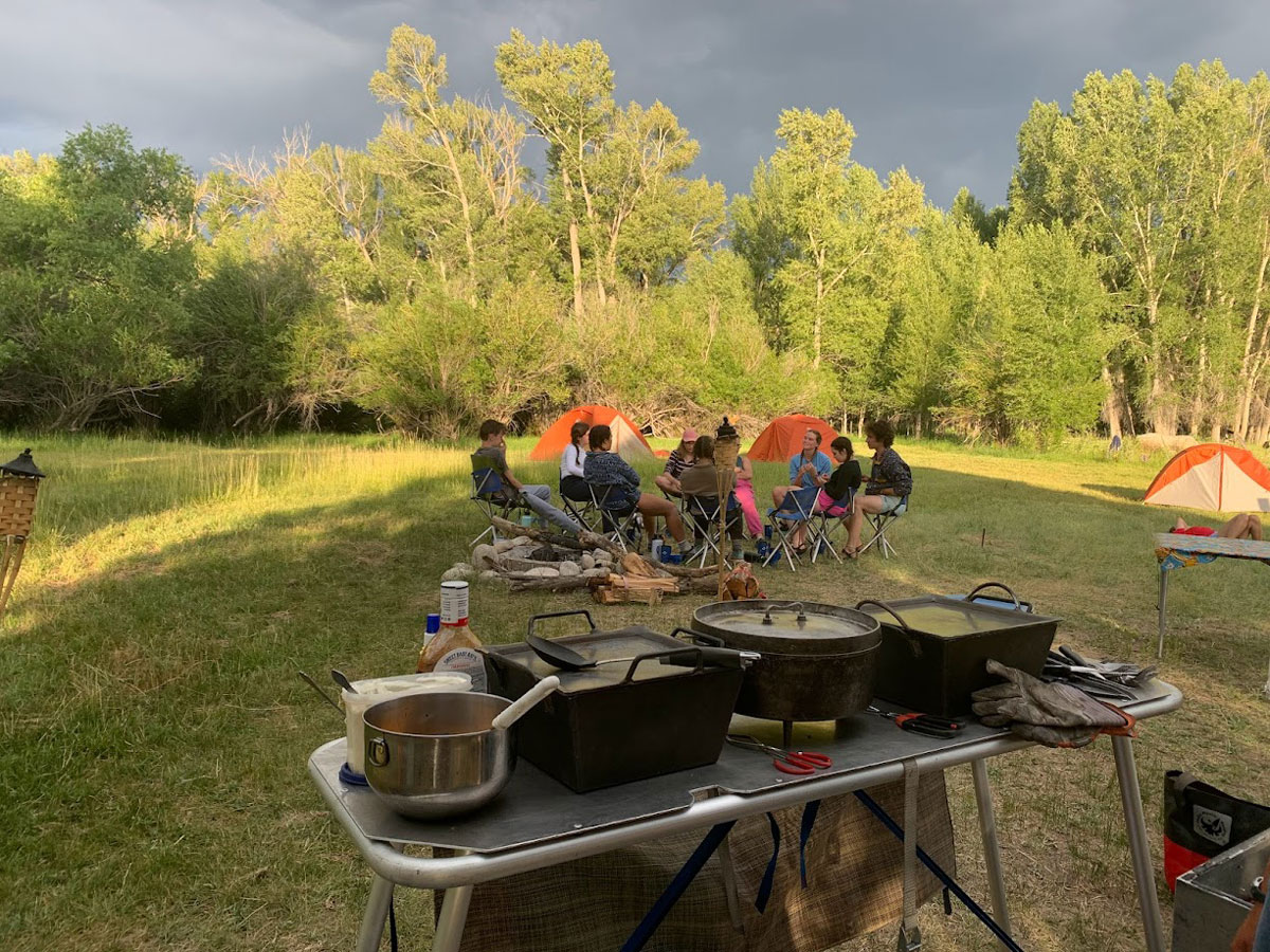 Rafters gather around a campfire during a cookout on a multi-day trip with Wilderness Aware Rafting