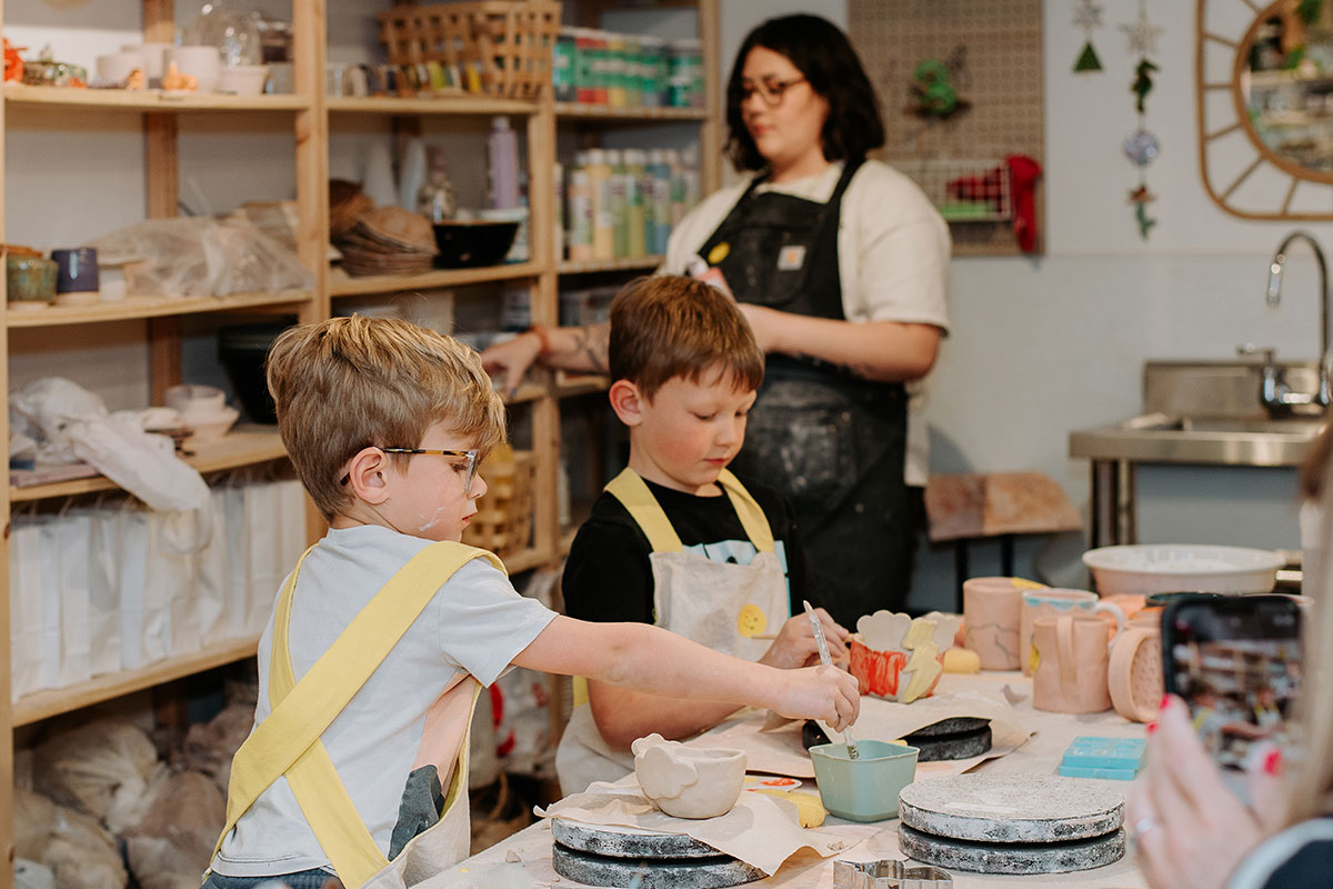 Children paint pottery at Friend Assembly studio in Aurora, Colorado