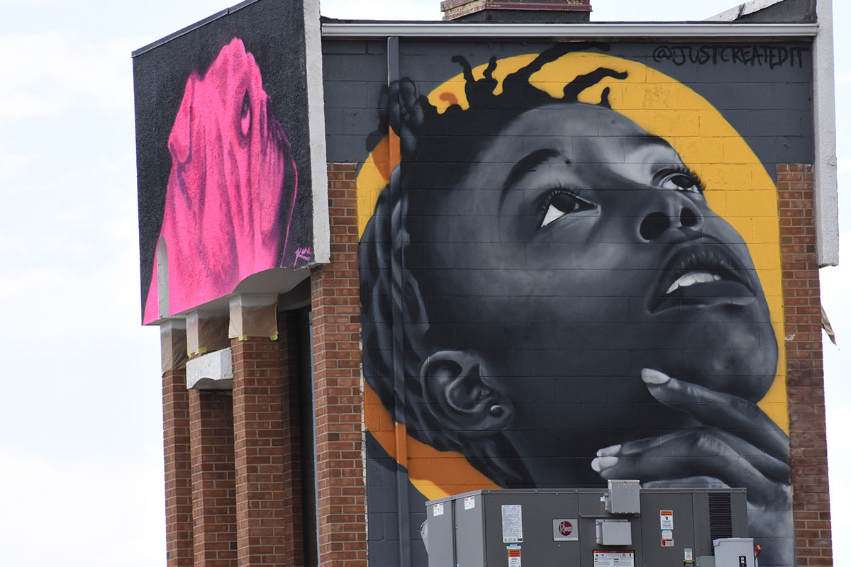  A large mural of a person’s face painted on the side of a building in Aurora, Colorado