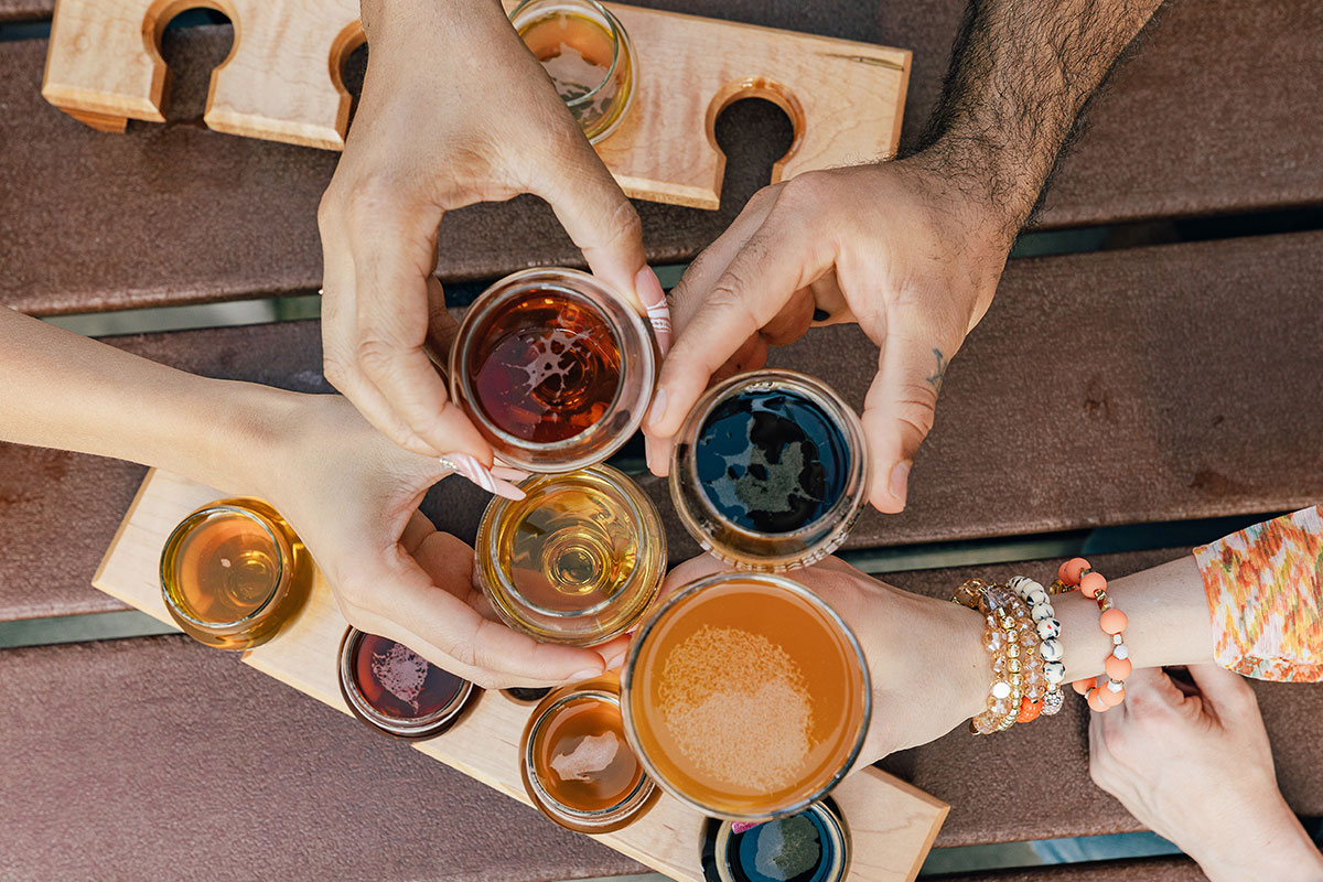A group of people clink glasses of craft beer during a tasting at a brewery in Aurora, Colorado