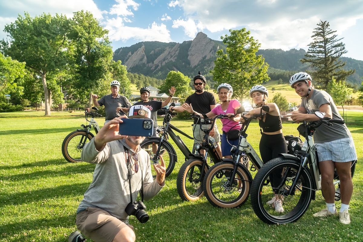 Group of e-bike riders stopping for a photo with mountains in the background in Colorado.