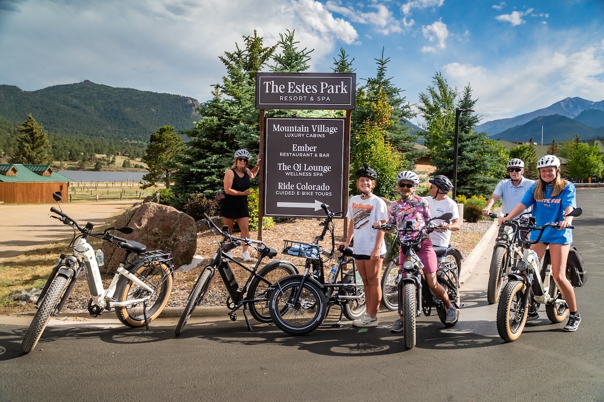 Family posing with e-bikes outside the Ride Colorado sign in Colorado.