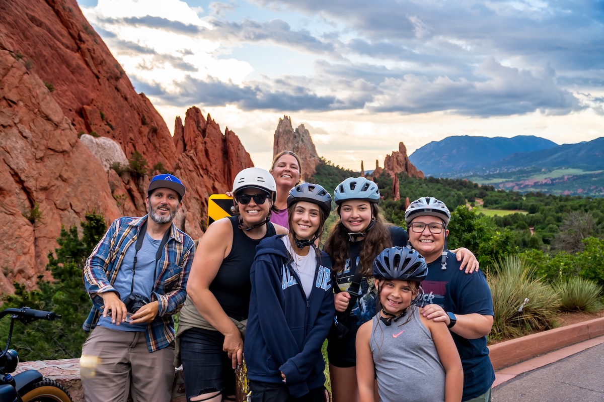 E-bikers at the Garden of the Gods with the red rocks behind them in Colorado.