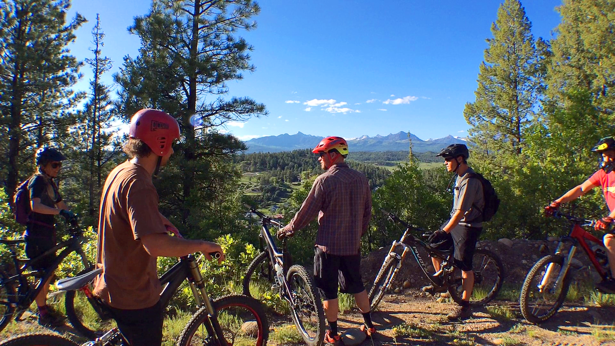 Mountain bikers pause along a trail overlooking panoramic mountain views in Pagosa Springs, Colorado.
