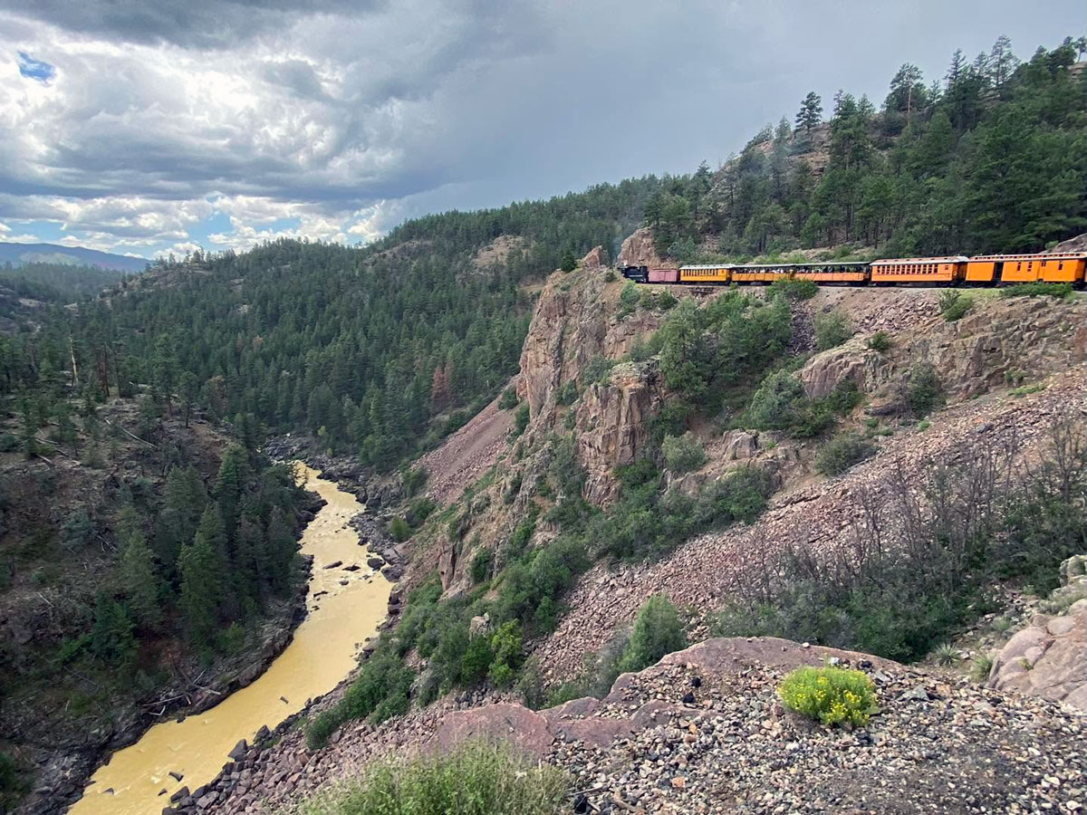 Durango & Silverton Narrow Gauge Railroad traveling along a rocky mountainside above the Animas River in Southwest Colorado.