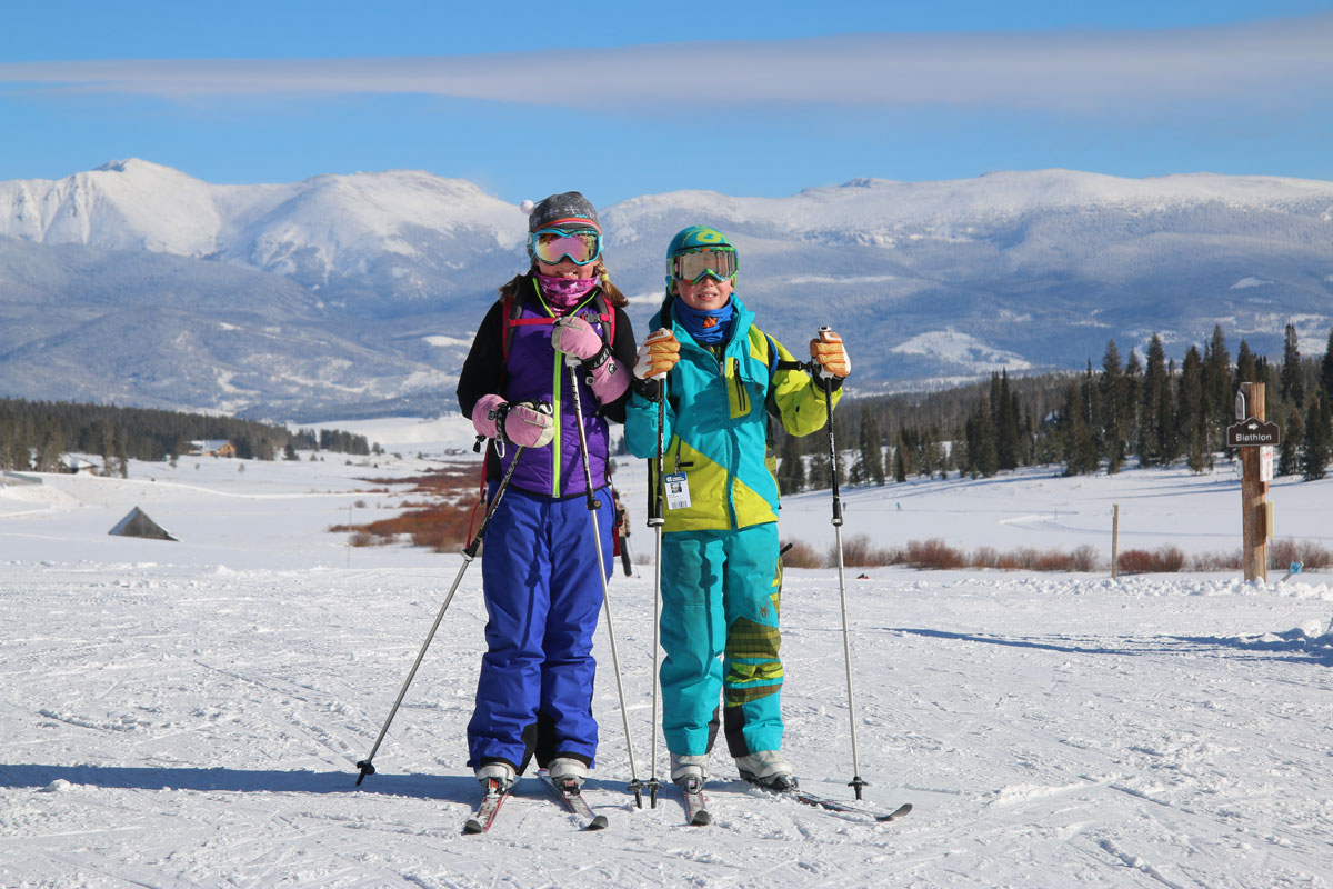 Cross-country skiers smiling with mountains in the background