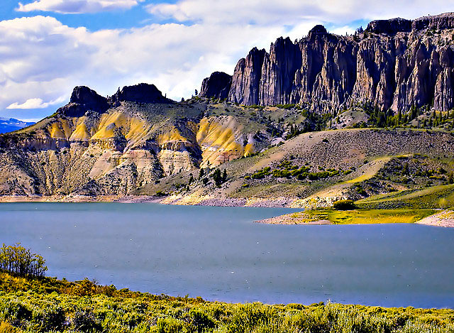 The winding fingers of Blue Mesa Reservior, near Gunnison, CO with fluffy clouds in the sky