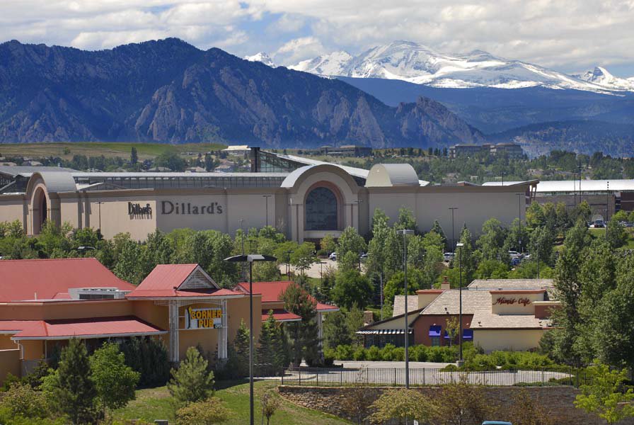 A mall sits in a valley with mountains in the background