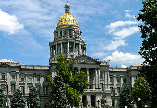 In Denver, Colorado, a shiny, golden dome caps the capitol building. The dome sits atop two tiers of tall windows and imposing columns.
