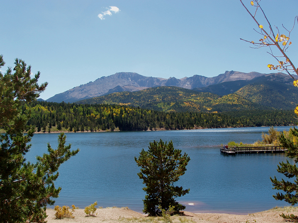 A lookout spot provides a view of blue waters and distant mountain peaks in Pike National Forest.