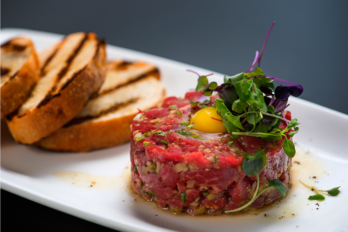 The steak tartar at Aurum in Steamboat Springs topped with microgreens with grilled bread on the side 