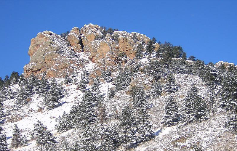 A snow-dusted ridge with frosty trees surrounding its slopes