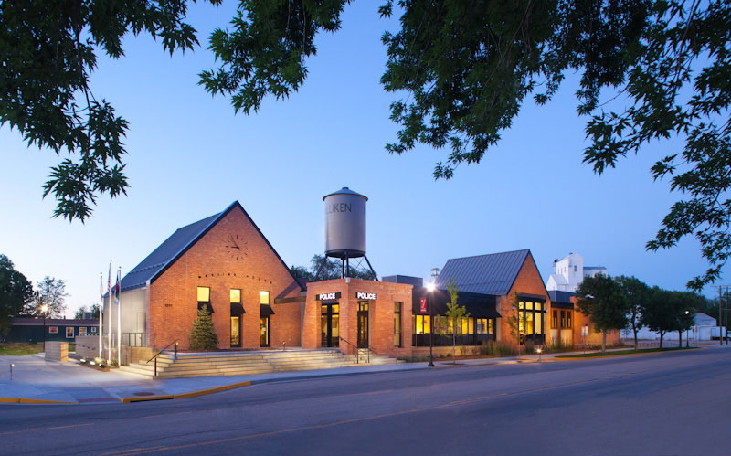 The red-brick town hall with the police office in Milliken at dusk.