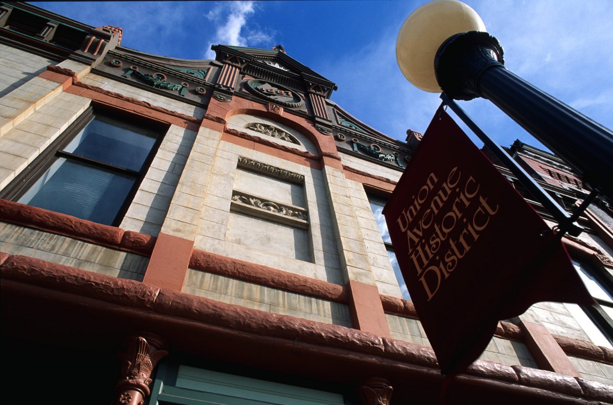 We look straight up at a lamppost with a sign that says "Union Avenue Historic District." The building behind is a white-stone marvel with wrought-iron details.