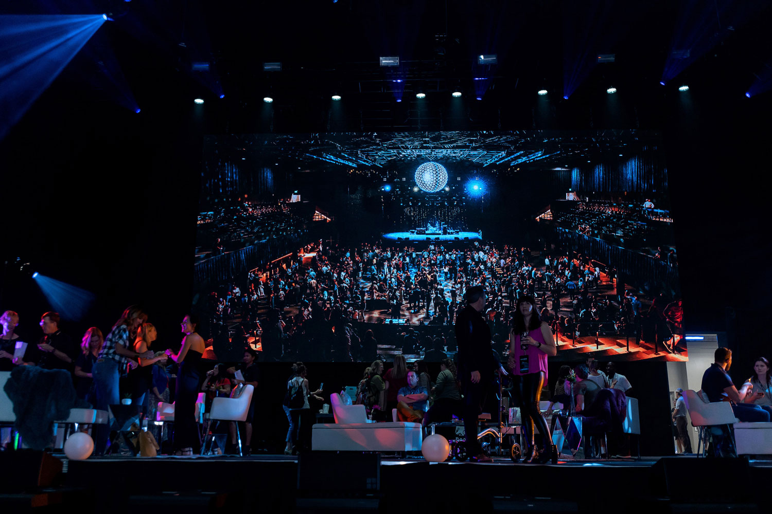 A crowd enjoys live music inside a darkened concert venue