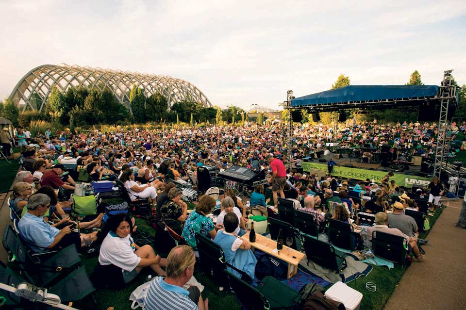 People sitting on a lawn at a concert on a summer day at Denver Botanic Gardens