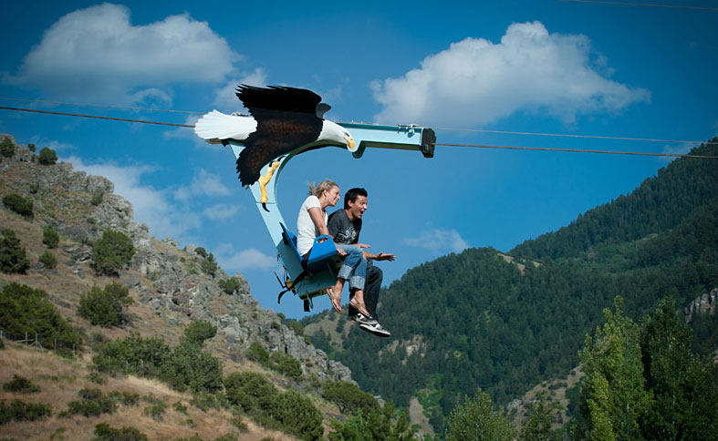 Two people smile as the zip across the Royal Gorge Bridge & Park's Soaring Eagle zip line, Cañon City, CO