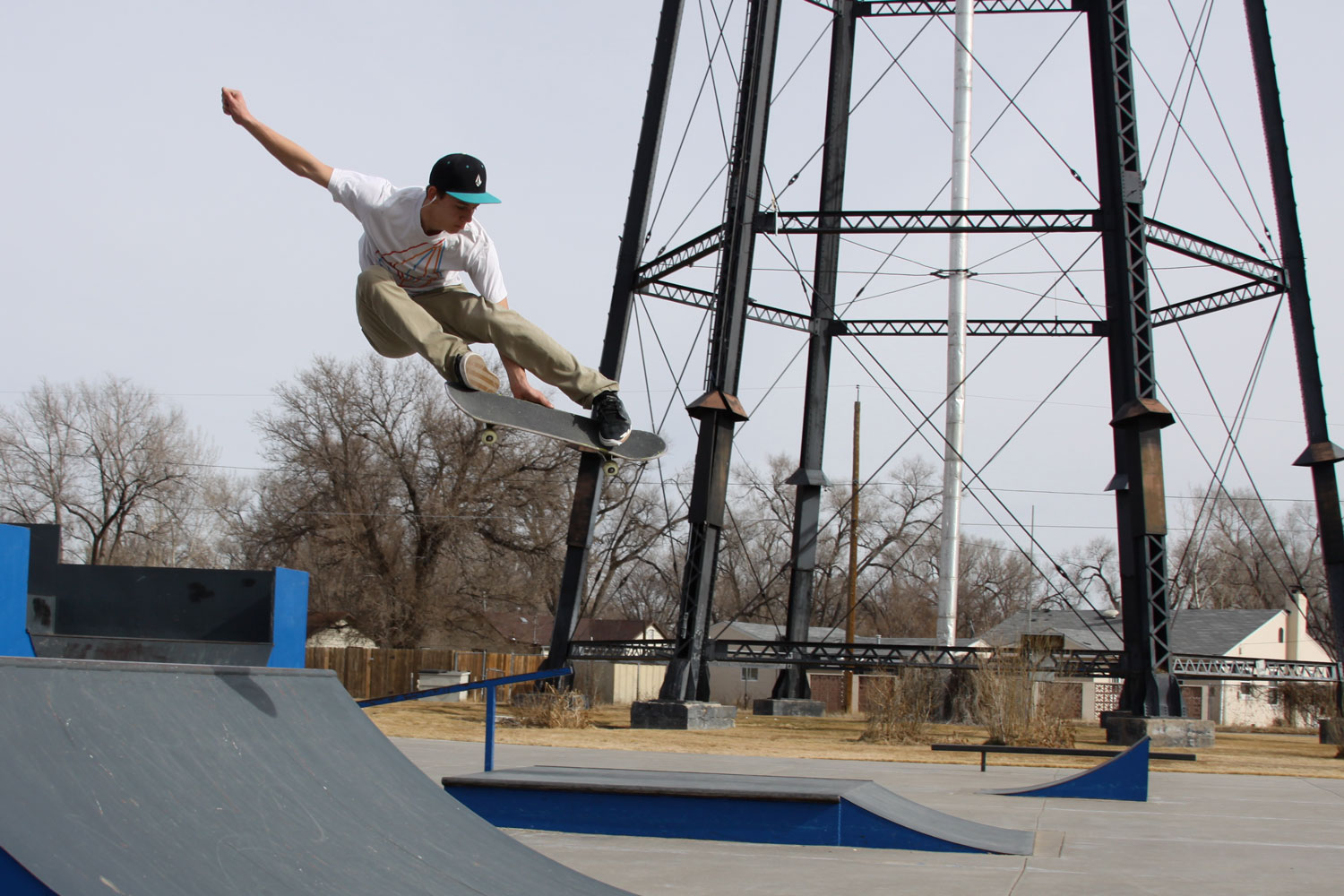 A person gets air on a skateboard at Tolla Brown Skate Park underneath a water tower.