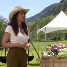 Colorado Top Chef Episode 12 Padma Lakshmi wears a cowboy hat and stands in front of a table of Colorado produce