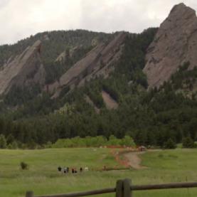 Boulder's Flatirons People in the distance walking a trail toward Boulder's Flatirons