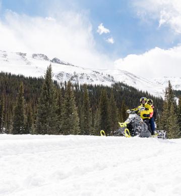 Snowmobiling in the Collegiate Peaks with mountains in forest in the background