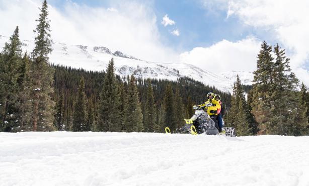 Snowmobiling in the Collegiate Peaks with mountains in forest in the background