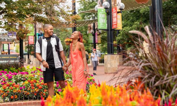 Couple walking along Pearl Street with flowers in the foreground.
