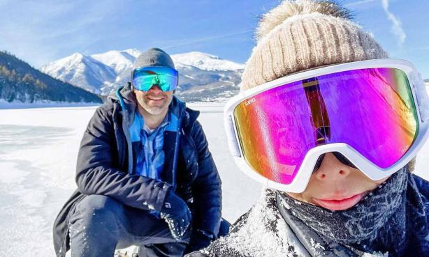Couple pauses for a snowshoe selfie near Leadville with mountains in the background.