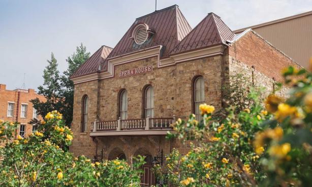 Old opera house with flowers in the foreground.