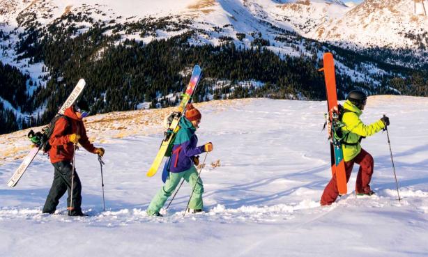 Three people with skis explore Colorado's back country.