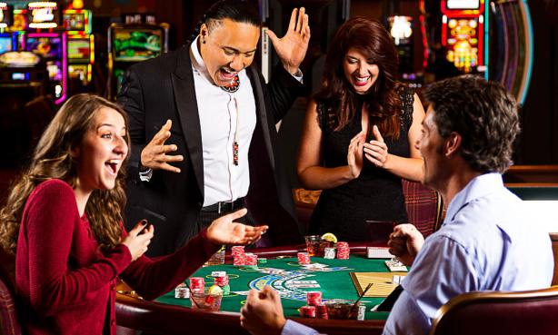 A group of people celebrating around a casino game table